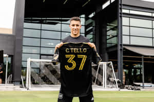 Cristian Tello Holding Jersey Number37 Wallpaper