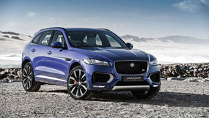 Cruise The Open Road In A Stylish Blue Jaguar Car Wallpaper