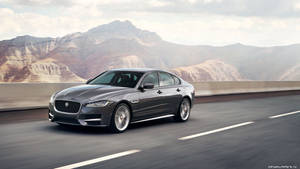 Cruising The Road In Style In A Grey Jaguar Wallpaper