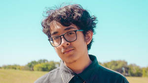 Cuco With His Black Shirt And Eyeglasses Wallpaper