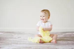 Cute Laughing Baby On The Floor Wallpaper