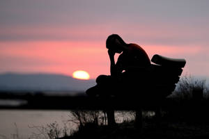 Dark Sad Man Seated On Bench Wallpaper