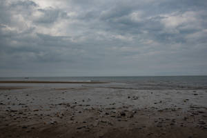 Dark Seashore Under Cloudy Sky Wallpaper