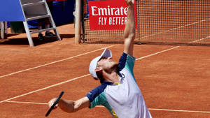 David Goffin Demonstrating A Powerful Serve In Action Wallpaper