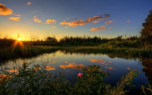 Dawning Sun Over A Peaceful River Wallpaper