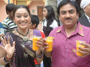 Dayaben And Jethalal Holding Orange Juice Wallpaper