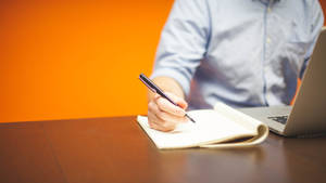 Dedicated Entrepreneur Jotting Down Ideas Wallpaper