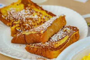 Delicious, Golden French Toast With A Side Of Fresh Berries And A Drizzle Of Maple Syrup Wallpaper