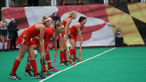 Determined Field Hockey Players Gearing Up For The Match Wallpaper