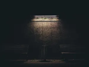 Dim Light Casts A Gentle Glow Over A Brown Painted Wall Wallpaper