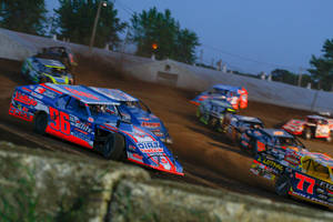 Dirt Cars Racing On A Dirt Track Wallpaper