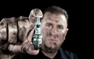 Dirty Man Holding Spark Plug Wallpaper
