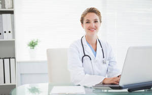 Doctor Examining Patient In A Medical Office Wallpaper