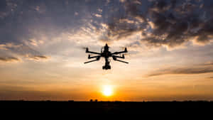 Drone Silhouette Against Sunset Sky Wallpaper