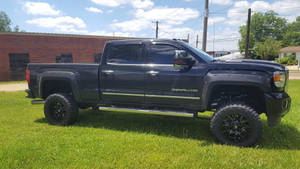 Duramax Parked On A Grassy Field Wallpaper