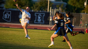 Dynamic Action In Girls' Division Flag Football Game Wallpaper