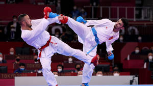 Dynamic Karate Athletes Showcasing A Double Kick Wallpaper