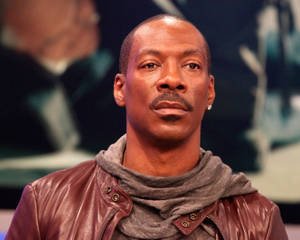 Eddie Murphy Looking Suave In A Brown Leather Jacket Wallpaper