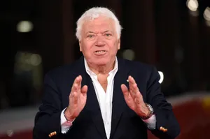 Elderly Gentleman Gesturing During Event Wallpaper