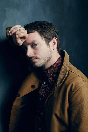 Elijah Wood In A Brown Denim Jacket Wallpaper