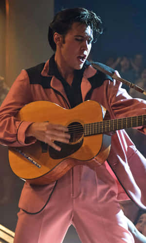 Elvis Presley In Pink Suit Playing Guitar Wallpaper