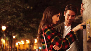 Emily, Played By Lily Collins, And Gabriel, Played By Lucas Bravo, Enjoying A Romantic Moment In Paris. Wallpaper