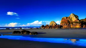Enjoy A Stunning View Of A Shallow Beach With Rocks Wallpaper