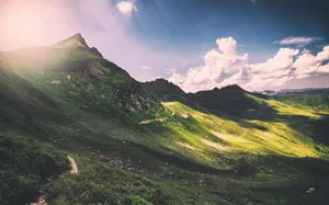 Enjoy Nature's Beauty In This Majestic Green Mountain Wallpaper