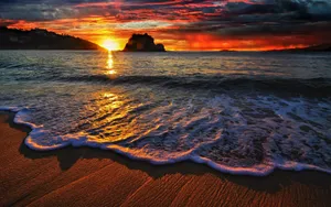 Enjoy The Beauty Of A Beach Sunset Wallpaper