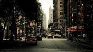 Enjoy The Hustle And Bustle Of New York City On A Lively Street In The City Wallpaper