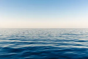 Enjoy The Magical View Of A Never Ending Horizon Of Blue Ocean Water. Wallpaper