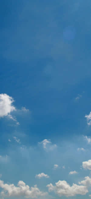 Enjoy The Peaceful Blue Skies With White Clouds Wallpaper