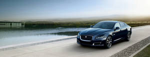 Enjoy The Thrill Of Driving A Luxurious Matte Black Jaguar Wallpaper