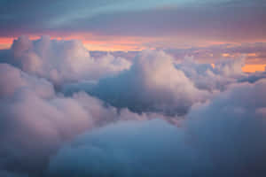 Enjoy The Views Of Beautiful, Fluffy Clouds In A Bright Blue Sky. Wallpaper