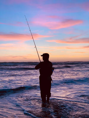 Enjoying A Day Of Fishing On The Beach Wallpaper