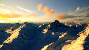 Enjoying The Beauty Of Snowy Mountain Peaks Wallpaper