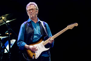 Eric Clapton Striking A Pose In His Signature Blue Polo Wallpaper