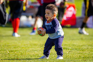 Excited Young Boy Playing Football On Phone Wallpaper