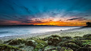 Experience The Beauty Of A Beach Sunset Wallpaper