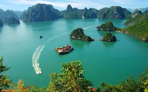 Fast Speed Boat Cruising Through Majestic Halong Bay Wallpaper