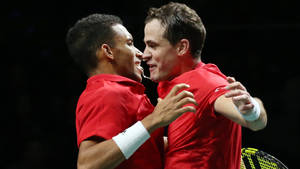 Felix Auger-aliassime Celebrating A Victorious Moment On The Tennis Court With A Jubilant Chest Bump. Wallpaper