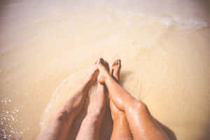 Female And Male Feet On The Seawater Wallpaper