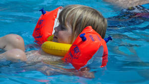 Floating Kid In Swimming Pool Wallpaper