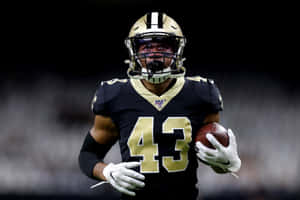 Focused Football Player Holding Ball Wallpaper