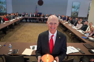 Former Florida Governor Rick Scott, Holding A Cake During A Celebration. Wallpaper