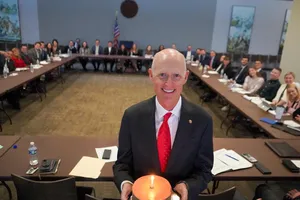 Former Florida Governor Rick Scott, Holding A Cake During A Celebration. Wallpaper