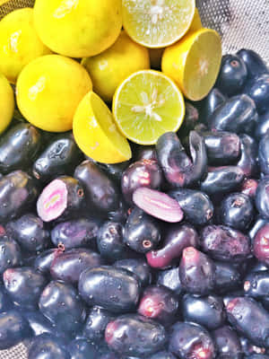 Freshly Harvested Java Plums And Lemons Wallpaper