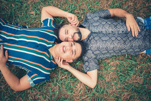 Gay Men Lying On Grass Wallpaper