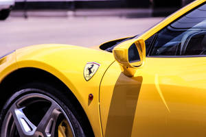 Get Ready To Feel The Rush Of The Wind In The Open Road With This Yellow Ferrari Sports Car. Wallpaper