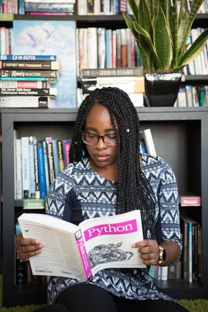 Girl Reading Reference Book For Coding Wallpaper